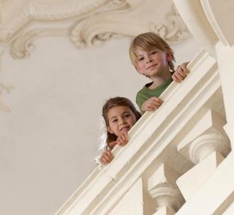 Kinder an einer Balustrade im Schloss